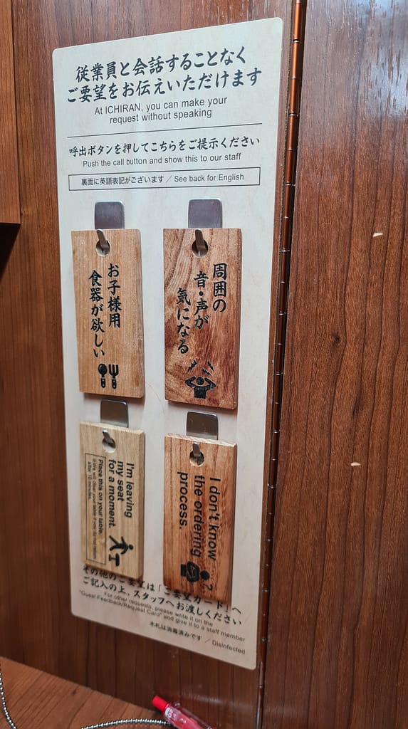 Diese Holzplättchen konnte man dem Personal geben, wenn man etwas signalisieren wollte. Vorne stand es auf japanisch, hinten auf englisch